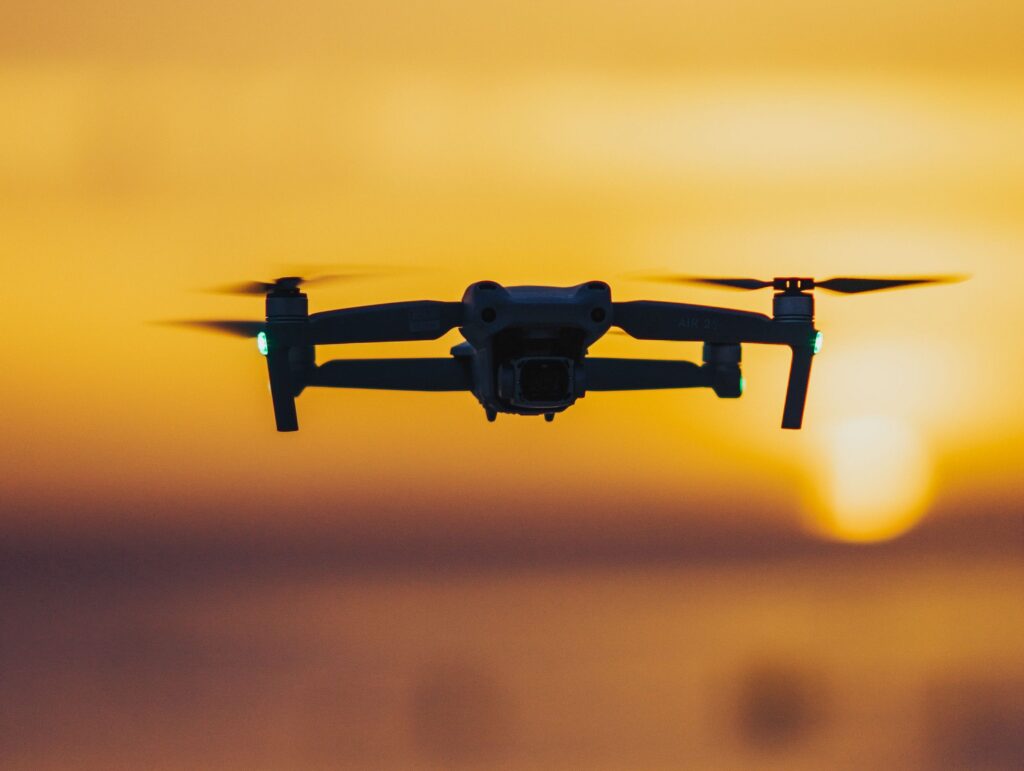 Private 5-Day Normandy Tour A drone flies over the ocean with a stunning sunset backdrop, casting a serene silhouette.